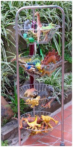 three tiered metal plant stand with plants in the back ground and leaves on it