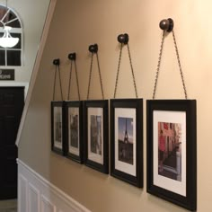 three framed pictures hanging on the wall with chains attached to them, and one has an instagram