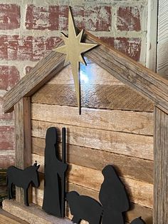 the nativity scene is made out of wood and has a star on top of it