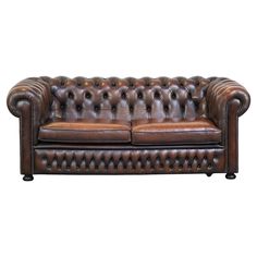 a brown leather couch sitting on top of a white floor