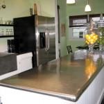 a kitchen with stainless steel counter tops and black appliances in the center, along with checkered flooring