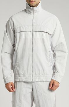 This relaxed-fit track jacket is part of a collab with PLEASURES and is inspired by a clash of racing and punk-inspired streetwear. Bold tonal branding for both labels subtly reflects against the sleek nylon on the outerwear, while underarm ventilation keeps it breathable throughout the day. 28" length (size Medium) Front zip closure Stand collar Elastic cuffs and hem Side zip pockets Underarm ventilation Water-repellent 100% recycled nylon Machine wash, tumble dry Imported PUMA has received the