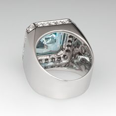 This captivating ring is centered with one (1) square emerald cut natural aquamarine set into a four-prong setting. The top and side faces of the ring are accented with forty-eight (48), prong set, round brilliant cut diamonds. The ring measures 18.0mm at the top, rises 7.7mm above the finger, tapering to 7.8mm wide and 0.7mm thick at the base of the shank. This ring is currently a size 7. The aquamarine shows moderate nicks and abrasions. Luxury Formal Emerald Ring With Radiant Cut, Luxury Topaz Ring Emerald Cut With Vvs Clarity, Luxury White Gold Topaz Ring Emerald Cut, Luxury Emerald-cut Topaz Ring With Vvs Clarity, Luxury Topaz Ring With Prong Setting, Luxury Emerald Ring With Square Cut Diamond, Luxury Square Cut Diamond Emerald Ring, Luxury Square-cut Emerald Ring With Diamonds, Luxury Square Cut Emerald Ring With Diamonds