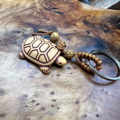 a turtle shaped keychain sitting on top of a wooden table