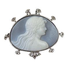 This is one of the most beautiful Antique Art Nouveau - Belle Epoque Hardstone Cameo Brooches we have seen. The extraordinary hand carved image of the woman, or Goddess, is framed by a halo of Rose Cut Diamonds set in Platinum atop 14 Karat Gold. The Art Nouveau cameo artisans created some of the most exquisite hard stone cameos the world has ever seen and this is one of the finest examples. The cameo is carved from a blue and white hard stone that is known as Chalcedony. The gem has a stunning light blue color background that lets just the perfect amount of light through to highlight the white stone of the goddess woman. The carving is the work of a master artisan. The face is a masterpiece of artistic expression, and is carved with exquisite detail throughout, the hair is stunning, and I Light Blue Color Background, Blue Color Background, Bijoux Art Nouveau, Magical Art, Cameo Brooch, Antique Diamond, Gold Art, Light Blue Color, Belle Epoque