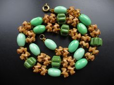 For sale is this lovely vintage necklace dating from the Art Deco era. It features a mix of green and caramel brown glass beads, a typical colour combination of that period. There are oval, ribbed and waved beads all strung onto thread.  The length of the necklace is 42cm/16.5" which is inclusive of the working brass bolt ring fastener. The necklace is in very good vintage condition with no chips or cracks, just light surface wear in keeping with age. A stylish period piece. Retro Green Beaded Necklace For Gift, Vintage Green Handmade Necklaces, Vintage Green Czech Glass Jewelry, Handmade Retro Green Beaded Necklace, Vintage Green Round Bead Necklaces, Vintage Green Necklaces With Round Beads, Antique Green Beaded Necklace As Gift, Antique Green Beaded Necklace For Gift, Green Vintage Necklace