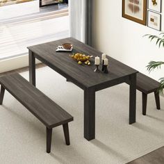 a dining table with two benches next to it in front of a window and potted plant