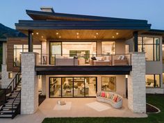 a modern house with an outdoor living area and stairs leading up to the upper level