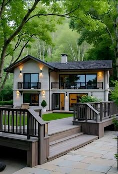 a house with stairs leading up to the front door and trees in the back yard