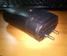 an electric charger sitting on top of a wooden desk next to a computer keyboard