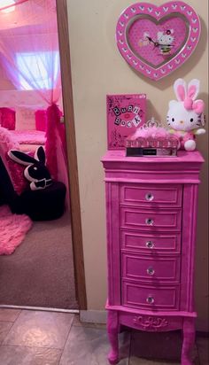 a pink dresser with hello kitty decorations on it