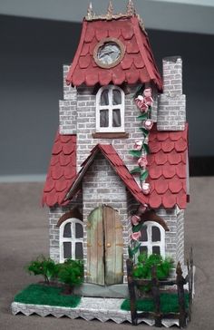 a small house with a clock on the top of it