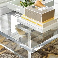 a glass coffee table with books stacked on top