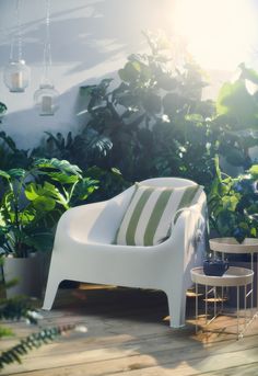 a white chair sitting on top of a wooden floor next to potted plants and tables