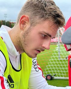 a young man sitting on top of a soccer field