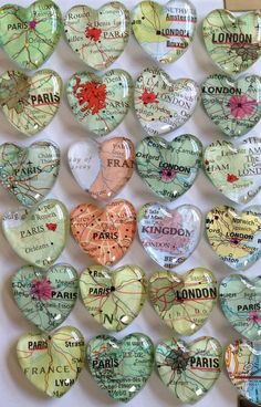 many heart shaped glass magnets are arranged on a white surface with the words paris in different languages