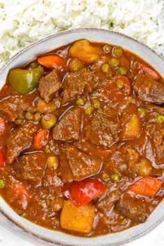 a bowl filled with meat and vegetables next to rice