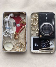 two tins filled with assorted items sitting on top of a table