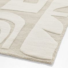 a white rug with an abstract design on the top and bottom, in front of a white background