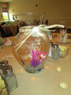 there is a vase with flowers in it on the dining room table at this wedding reception