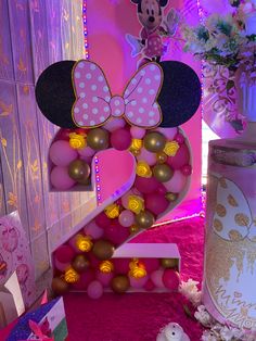 a minnie mouse birthday party with balloons and decorations