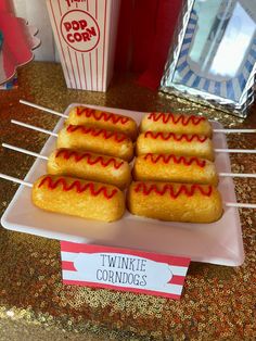 there are five hotdogs on a plate with toothpicks in front of them