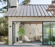 a living room with sliding glass doors and a potted plant in the corner on the patio