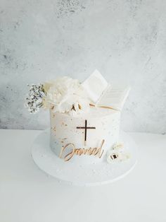 a white cake with flowers and a cross on top that reads, god's love