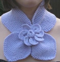 a woman wearing a blue knitted flower collar