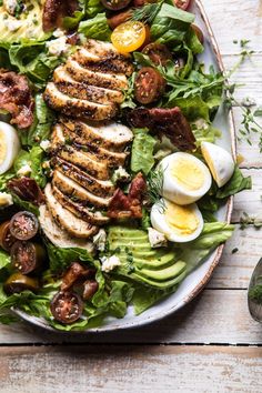 a white plate topped with salad and hard boiled eggs