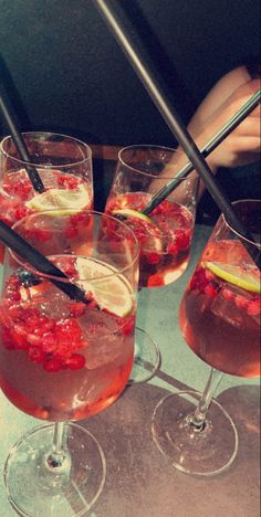 four glasses filled with different types of drinks on top of a table next to each other