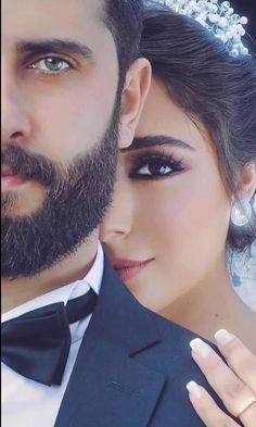 a man with a beard wearing a tuxedo next to a woman in a wedding dress