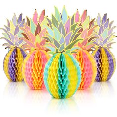 colorful paper pineapples and honeycombs arranged in a row on a white background