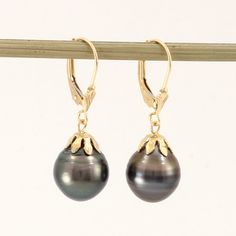 Brand New Solid Yellow Gold (not plated, not bonded) Tahitian Pearl Earrings Beautiful and unique well match dangle earrings. These Tahitian pearls finished with 14k solid yellow gold lever back and flower cap design. This genuine baroque Tahitian pearl earring is the epitome of natural beauty, grace. They are gaining popularity because of their unique look. The shimmering Tahitian pearl size is approximately width of 10.6mm. Due to their nature, no two pearls are alike, their nature making each pearl is one of kind. Therefore; we must send out exact pair on this listing if you purchase it. 1.Main Stone: Tahitian pearl 2.Color: Natural Black 3.Earring Size: approximately 10.6 mm width x 31mm length from bottom to the top (0.42 x 1.22 inches) 4.Earrings Total Weight: approximately 4.4 Grams Classic Tahitian Pearl Jewelry With Matching Earrings, Classic Tahitian Pearl Earrings As Gift, Classic Tahitian Pearl Earrings For Gift, Elegant Black Teardrop Pearl Earrings, Classic Tahitian Pearl Earrings For Anniversary, Tahitian Pearl Drop Earrings Gift, Tahitian Pearl Jewelry With Matching Earrings For Anniversary, Tahitian Pearl Jewelry With Matching Earrings For Gift, Tahitian Pearl Jewelry Set With Matching Earrings For Gift