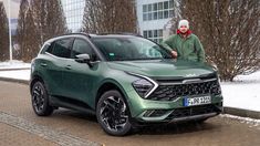 a man standing next to a green suv