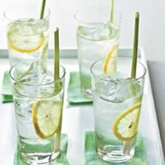 three glasses filled with water and lemons on top of a white tray next to each other