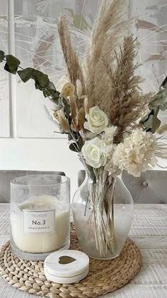 a vase with flowers and candles on a table