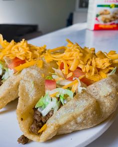 two tacos on a plate with cheese and other toppings