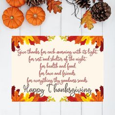 a thanksgiving greeting card with autumn leaves and pine cones on a white wooden table top