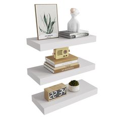 three shelves with books, clock and plants on them