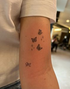 a woman's arm with butterflies and the word mom written on it in cursive writing