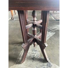 an old wooden table with four legs and one leg turned upside down on the ground