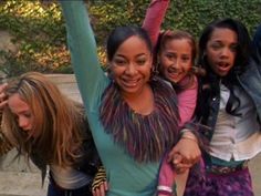 four girls are posing for the camera with their arms in the air