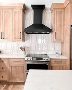 a kitchen with marble counter tops and wooden cabinets, along with an oven hood over the range