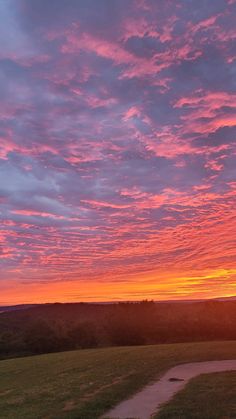 the sun is setting over an open field