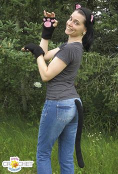 a woman in jeans and cat mitts poses for the camera