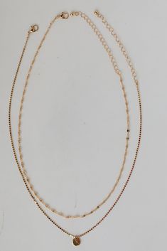 We're getting all the high roller vibes from the Emery Gold Layered Chain Necklace! This trendy necklace features two layers of gold chains with a circle charm on the end. Style the Emery Necklace with any outfit to instantly upgrade your look! Gold Plated Circle Charm Lobster Clasp with Extender Layer 1 | Length 7.5" Layer 2 | Length 7" Extender | Length 3" Gold Layered Charm Necklace Choker, Double Strand Metal Necklace With Delicate Chain, Trendy Double Strand Charm Necklace With Delicate Chain, Gold-tone Layered Choker Necklace With Adjustable Chain, Gold-tone Clavicle Chain Layered Choker Necklace, Gold-tone Layered Choker Necklace With Clavicle Chain, Gold-tone Choker-style Layered Necklace With Adjustable Chain, Gold-tone Layered Clavicle Chain Choker, Trendy Double Strand Layered Necklace With Adjustable Chain