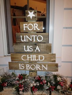 a wooden sign that says for unto us a child is born in front of a door