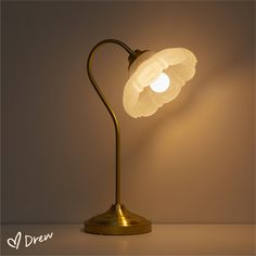 a lamp that is sitting on top of a table with a light bulb in the shape of a flower