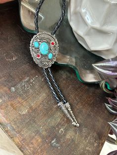 This awesome bolo tie has a southwestern design and faux turquoise pieces. The cord is genuine leather.   Measurements/Sizing   Total length of leather is approx. 40 inches 2 3/8 x 2 7/8 in pendant Bohemian Lariat Bolo Ties For Festivals, Artisan Turquoise Bolo Ties With Concho, Bohemian Turquoise Lariat Bolo Tie, Southwestern Turquoise Lariat Bolo Tie, Handmade Southwestern Turquoise Bolo Ties, Adjustable Turquoise Bolo Tie For Rodeo, Adjustable Turquoise Bolo Ties For Rodeo, Bohemian Lariat Bolo Tie For Rodeo, Southwestern Bolo Ties With Concho